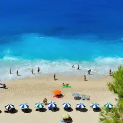 Piękna plaża w Grecji, idealna pogoda w październiku. Ludzie kąpią się i opalają, ciesząc się słońcem.