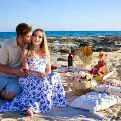 Romantyczny piknik na plaży na Cyprze. Para cieszy się chwilą, a w tle widać morze. Idealne miejsce na wycieczki fakultatywne po polsku.