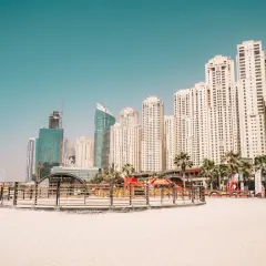 Plaża z widokiem na drapacze chmur, gdzie jest Dubaj. Palmy i nowoczesna architektura tworzą miejski krajobraz.