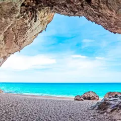 Widok z jaskini na piaszczyste plaże Alghero i turkusowe morze.