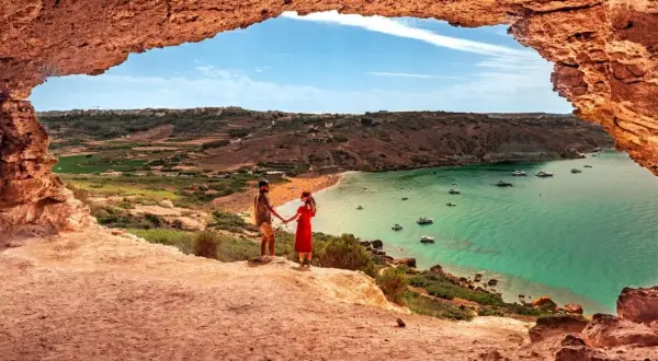 Para zakochanych podziwia widok na zatokę z łodziami. Malta pogoda wrzesień idealna na wakacje.
