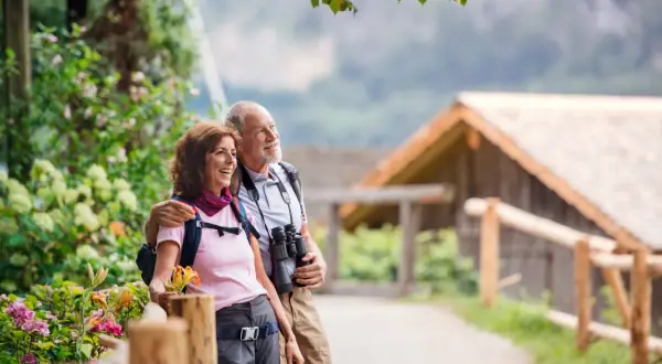 Szczęśliwa para seniorów w górach, odkrywająca piękne krajobrazy. Idealne tanie wczasy dla seniora za granicą.
