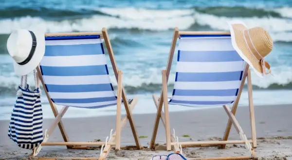 Dwa leżaki na plaży, kapelusze i torba plażowa. Idealne miejsce na algierskie wakacje.
