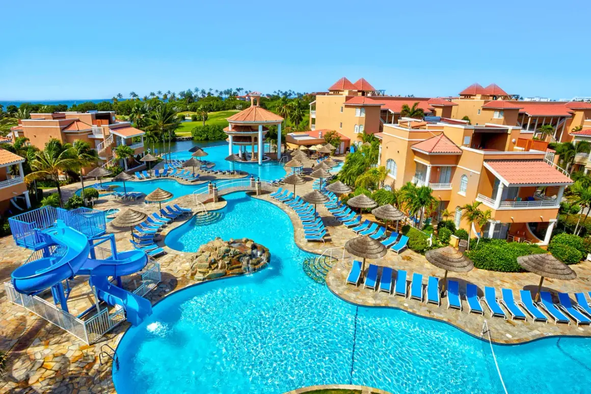 Idealne miejsce na aruba wakacje: luksusowy resort z basenami, zjeżdżalniami i palmami.