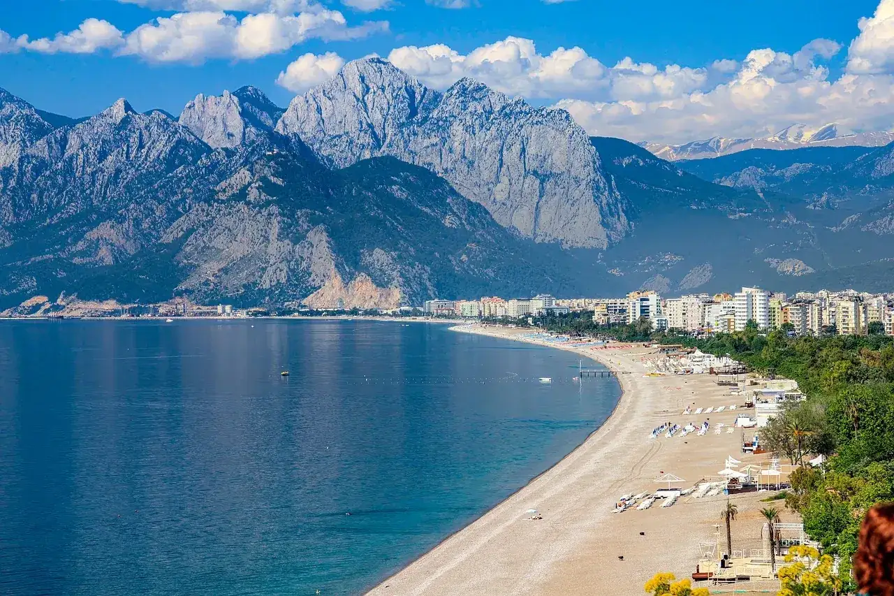 Widok na wybrzeże Kemer w Turcji. Góry Taurus w tle, plaża z leżakami i hotelami, turkusowe morze. Idealne miejsce na wakacje, odkryj kemer turcja atrakcje!